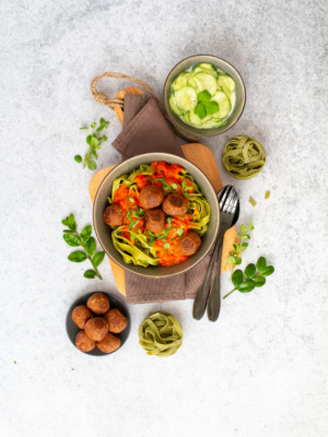 Köttbullar mit Bandnudeln und Tomatencremesauce und Gurkensalat